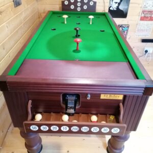 bar-billiards-riley-apr-2022-1 - Masters Traditional Games - Masters Traditional Games Vintage billiards table with green cloth and wooden frame; several balls placed on the table and a small score backing behind it.