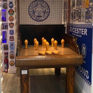 Vintage wooden tabletop peg football game with yellow pegs and a Leicester City FC logo on the backboard.